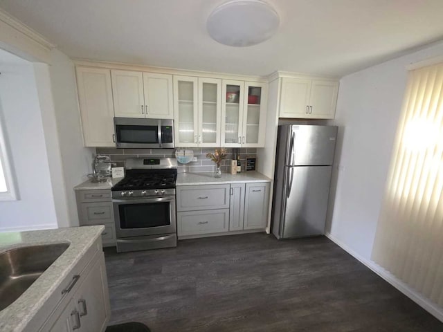 105 Marquette St, Park Forest, IL 60466 - kitchen with appliances with stainless steel finishes, decorative backsplash, dark wood-style floors, glass insert cabinets, and a sink