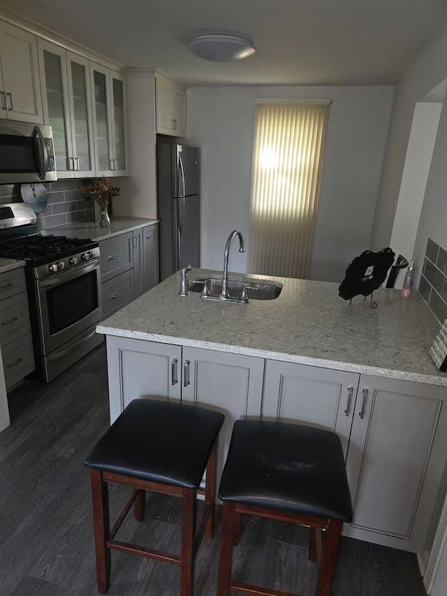 105 Marquette St, Park Forest, IL 60466 - kitchen with stainless steel appliances, a sink, light stone counters, tasteful backsplash, and glass insert cabinets