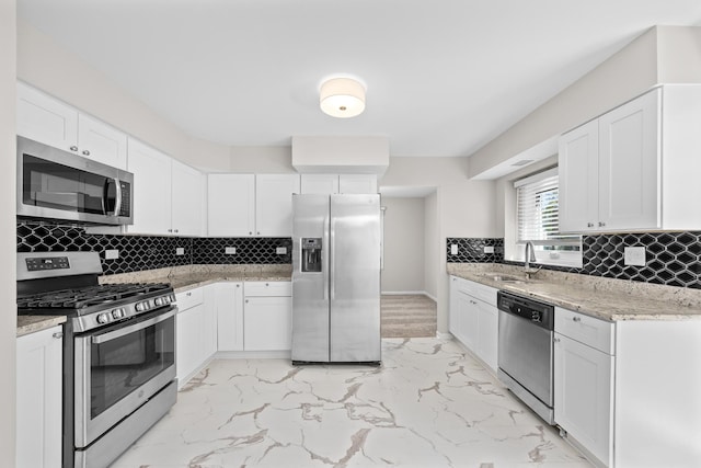 4435 Black Partridge Ln, Lisle, IL 60532 - kitchen with stainless steel appliances, a sink, light marble finish flooring, light stone countertops, and white cabinetry