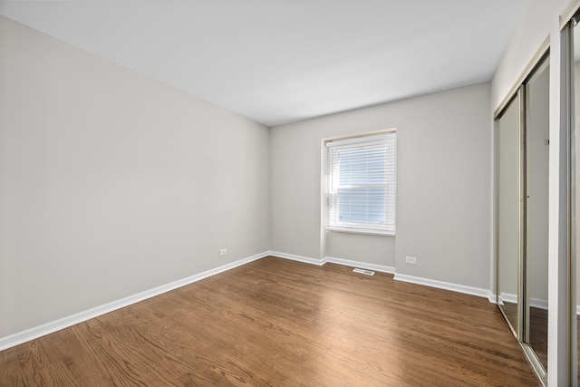 4435 Black Partridge Ln, Lisle, IL 60532 - unfurnished bedroom featuring dark wood-style floors, baseboards, and a closet