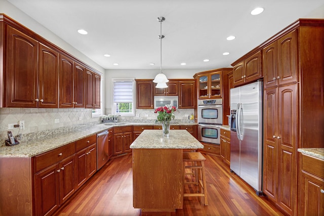 22665 Joshua Dr, Frankfort, IL 60423 - kitchen featuring appliances with stainless steel finishes, dark wood finished floors, tasteful backsplash, recessed lighting, and a breakfast bar area