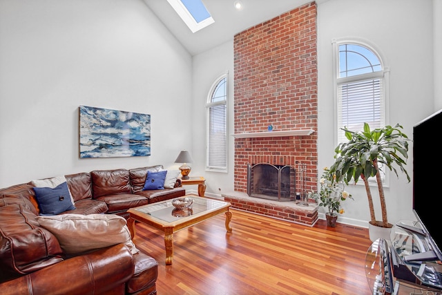 22665 Joshua Dr, Frankfort, IL 60423 - living room featuring high vaulted ceiling, a skylight, a fireplace, wood finished floors, and baseboards