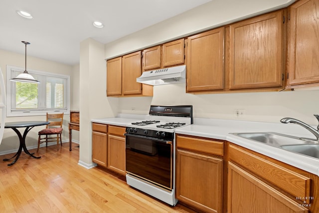 358 Bristol Ln, Fox River Grove, IL 60021 - kitchen with under cabinet range hood, gas stove, a sink, light countertops, and light wood-type flooring