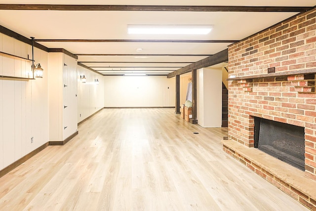 309 River Dr, Dekalb, IL 60115 - finished below grade area with a brick fireplace, light wood-type flooring, and baseboards