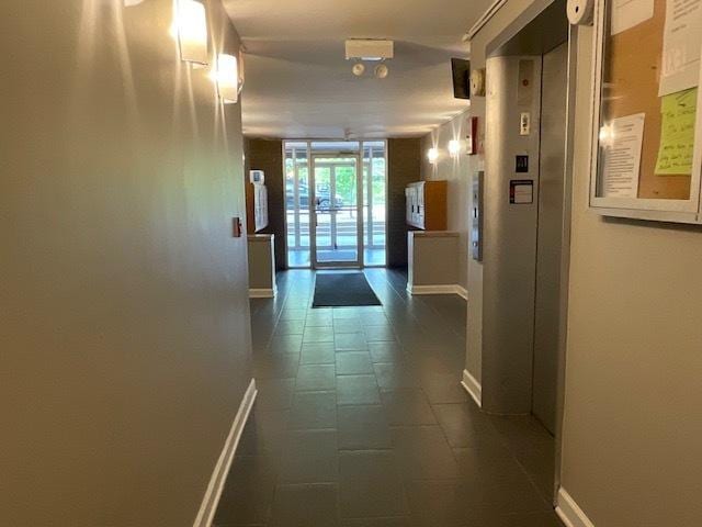 7854 S S Shore Dr Unit 306, Chicago, IL 60649 - corridor featuring baseboards, dark tile patterned flooring, and elevator