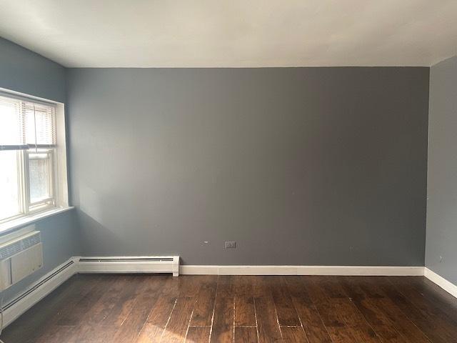 7854 S S Shore Dr Unit 306, Chicago, IL 60649 - unfurnished room featuring wood finished floors, baseboards, and a baseboard radiator
