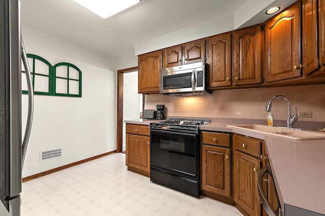 1144 Leavitt Ave, Flossmoor, IL 60422 - kitchen featuring stainless steel microwave, black range with gas cooktop, fridge, a sink, and backsplash