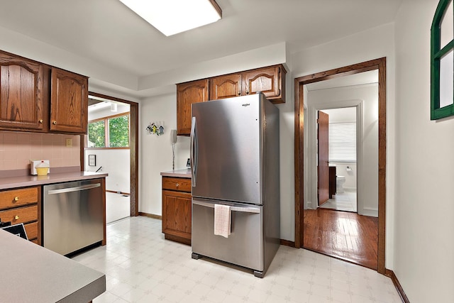 1144 Leavitt Ave, Flossmoor, IL 60422 - kitchen with stainless steel appliances, light floors, baseboards, backsplash, and light countertops