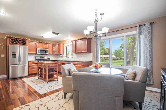 831 W Marywood Ave, Aurora, IL 60505 - dining area featuring a chandelier, dark wood-style flooring, healthy amount of natural light, and baseboards