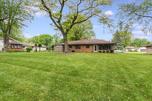 831 W Marywood Ave, Aurora, IL 60505 - rear view of house with a chimney, brick siding, and a yard