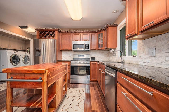 831 W Marywood Ave, Aurora, IL 60505 - kitchen with washer and clothes dryer, stainless steel appliances, light wood-style flooring, dark stone countertops, and a sink