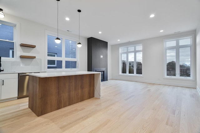 2417 W Walton St Unit 3, Chicago, IL 60622 - kitchen with dishwasher, white cabinetry, a center island, light countertops, and a large fireplace