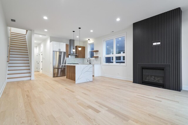 2417 W Walton St Unit 3, Chicago, IL 60622 - kitchen with high end fridge, wall chimney exhaust hood, a kitchen island, light countertops, and pendant lighting