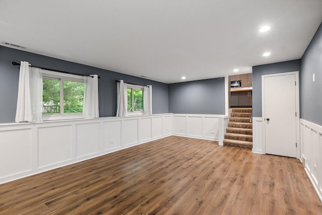 5S542 Tartan Ln, Naperville, IL 60563 - unfurnished room with a wainscoted wall, wood finished floors, a decorative wall, recessed lighting, and stairway