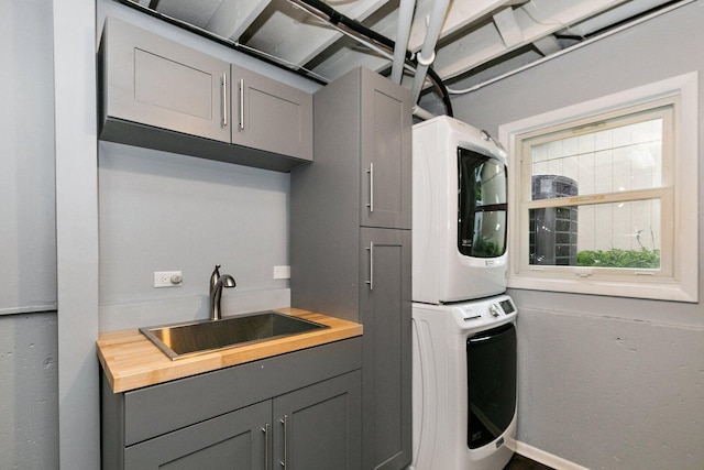 5S542 Tartan Ln, Naperville, IL 60563 - laundry area featuring stacked washer / dryer, cabinet space, and baseboards