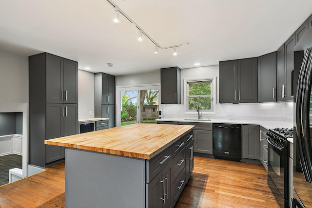 5S542 Tartan Ln, Naperville, IL 60563 - kitchen featuring black appliances, wood counters, rail lighting, a sink, and backsplash