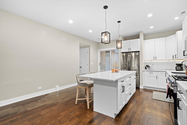7230 W Belden Ave Unit 1, Elmwood Park, IL 60707 - kitchen featuring appliances with stainless steel finishes, a center island, decorative backsplash, dark wood-style flooring, and white cabinets