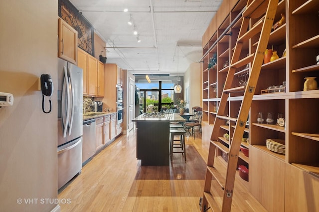 1530 S State St Unit 408, Chicago, IL 60605 - kitchen with appliances with stainless steel finishes, light wood-style floors, a kitchen bar, and a kitchen island