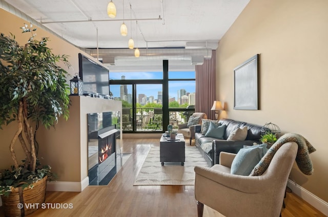 1530 S State St Unit 408, Chicago, IL 60605 - living area with a wall of windows, wood finished floors, a tiled fireplace, and baseboards