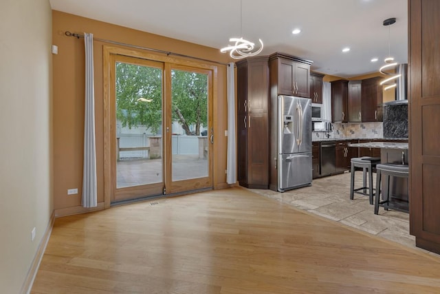 415 Honey Locust Ln, Willowbrook, IL 60527 - kitchen with appliances with stainless steel finishes, a chandelier, light wood-style floors, tasteful backsplash, and dark brown cabinets
