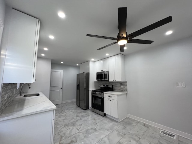 kitchen featuring appliances with stainless steel finishes, a sink, recessed lighting, a ceiling fan, and backsplash