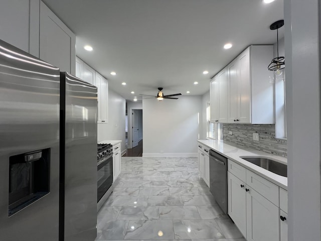 kitchen with stainless steel appliances, white cabinets, recessed lighting, light marble finish flooring, and a ceiling fan