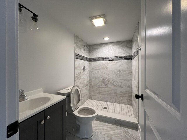 bathroom featuring a shower stall, toilet, vanity, and recessed lighting