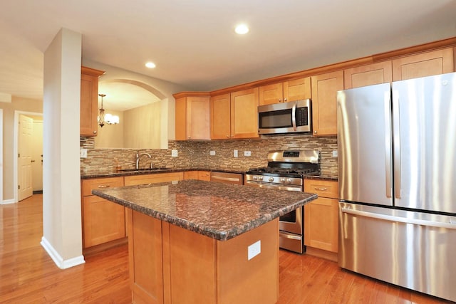 1437 Sturgeon Bay Ct, Schaumburg, IL 60173 - kitchen with stainless steel appliances, light wood-style flooring, a sink, tasteful backsplash, and a center island