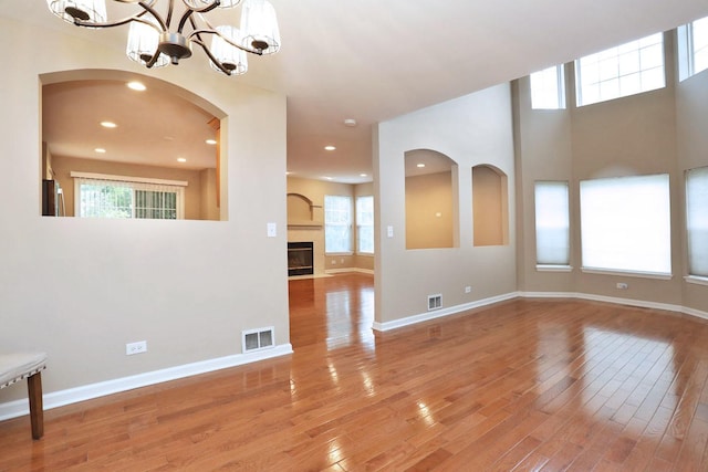 1437 Sturgeon Bay Ct, Schaumburg, IL 60173 - spare room with hardwood / wood-style floors, a chandelier, baseboards, a glass covered fireplace, and recessed lighting