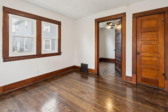 1006 W 1st St, Dixon, IL 61021 - empty room featuring baseboards, dark wood-style floors, a textured ceiling, and a ceiling fan