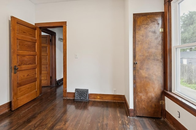 1006 W 1st St, Dixon, IL 61021 - unfurnished room with dark wood-style floors, plenty of natural light, and baseboards