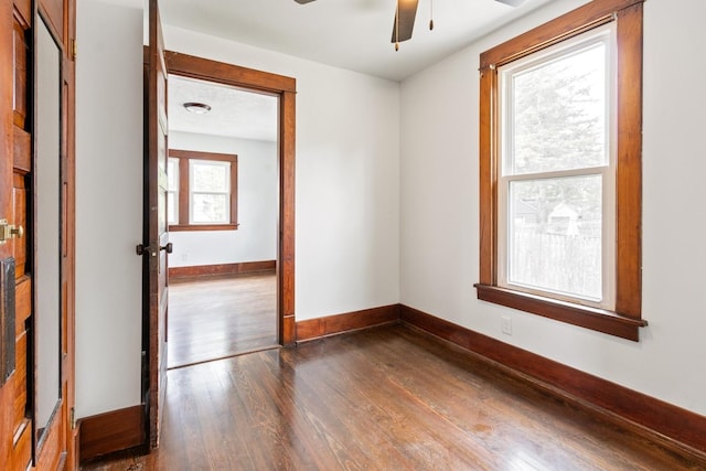 1006 W 1st St, Dixon, IL 61021 - empty room with dark wood-style flooring, ceiling fan, and baseboards
