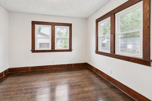 1006 W 1st St, Dixon, IL 61021 - spare room featuring dark wood finished floors, baseboards, and a textured ceiling