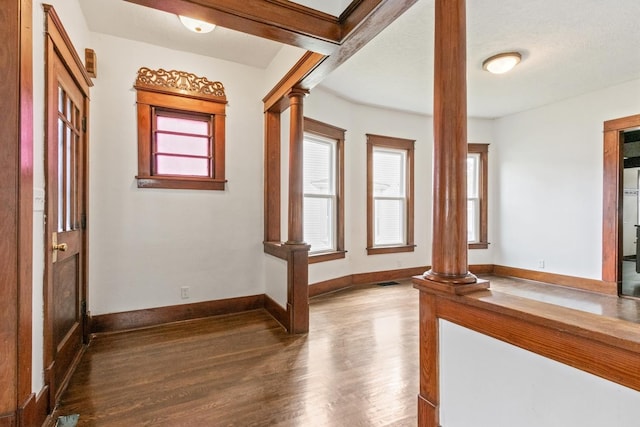 1006 W 1st St, Dixon, IL 61021 - hall with decorative columns, dark wood-style flooring, plenty of natural light, and baseboards