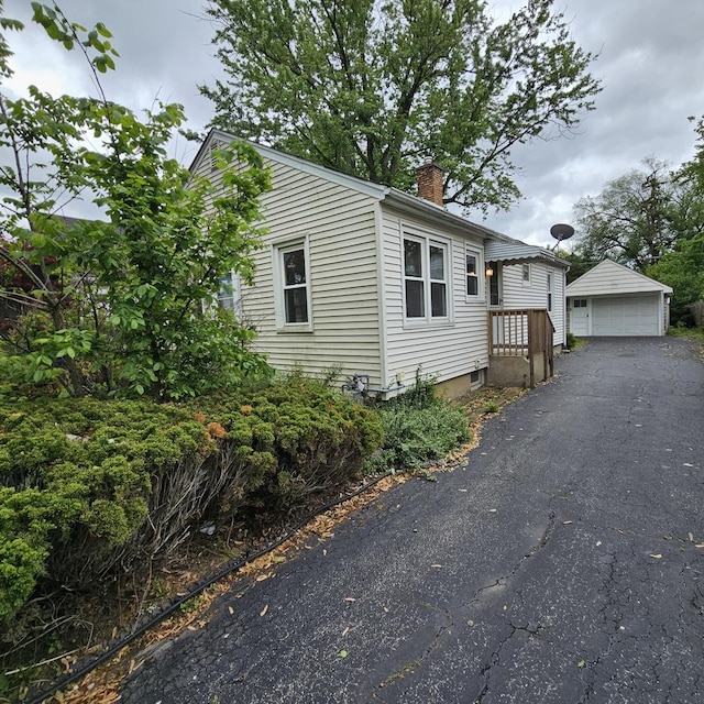 237 Pine St, Villa Park, IL 60181 - view of front of house with a chimney, a garage, and an outbuilding