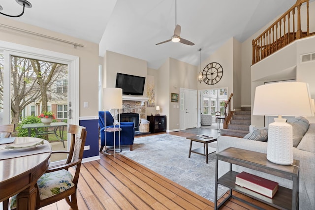 538 Pembrook Ct S, Crystal Lake, IL 60014 - living room featuring a stone fireplace, light wood-style floors, high vaulted ceiling, ceiling fan, and baseboards