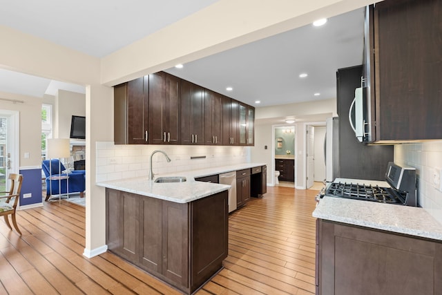 538 Pembrook Ct S, Crystal Lake, IL 60014 - kitchen with a sink, stainless steel appliances, light wood-style floors, dark brown cabinetry, and decorative backsplash