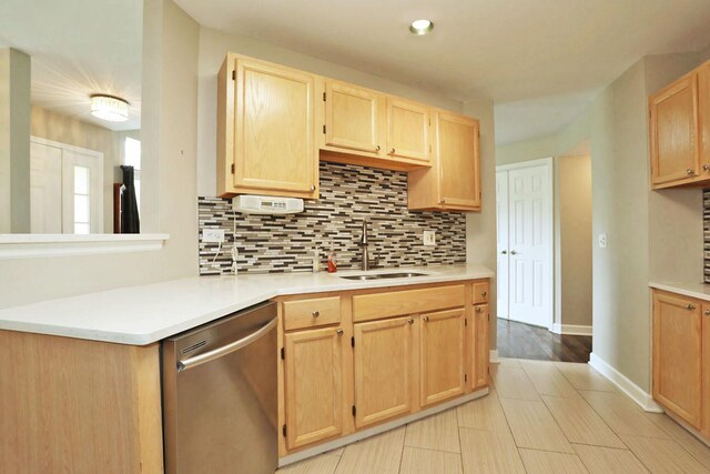 339 Ashford Cir Unit 1, Bartlett, IL 60103 - kitchen featuring stainless steel dishwasher, light brown cabinets, a sink, decorative backsplash, and light countertops