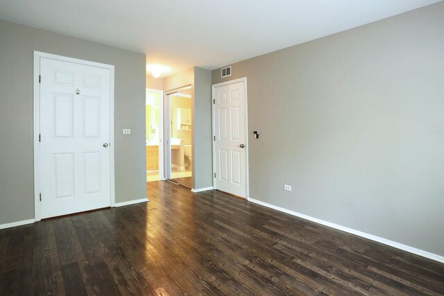 339 Ashford Cir Unit 1, Bartlett, IL 60103 - unfurnished bedroom featuring dark wood-style floors, baseboards, and connected bathroom