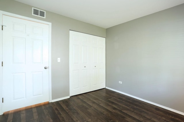 339 Ashford Cir Unit 1, Bartlett, IL 60103 - unfurnished bedroom featuring dark wood-style flooring, baseboards, and a closet