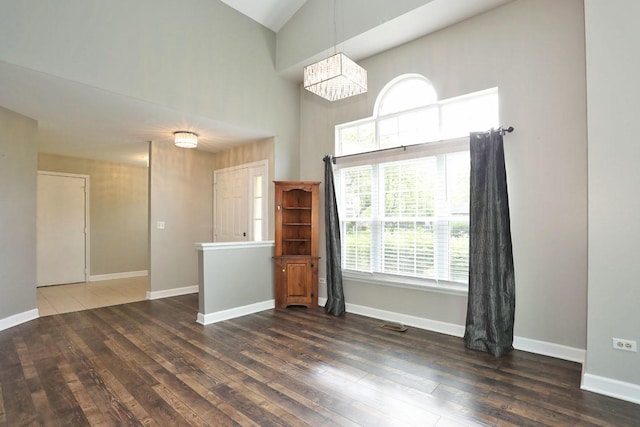 339 Ashford Cir Unit 1, Bartlett, IL 60103 - unfurnished room featuring hardwood / wood-style flooring, a high ceiling, a chandelier, and baseboards