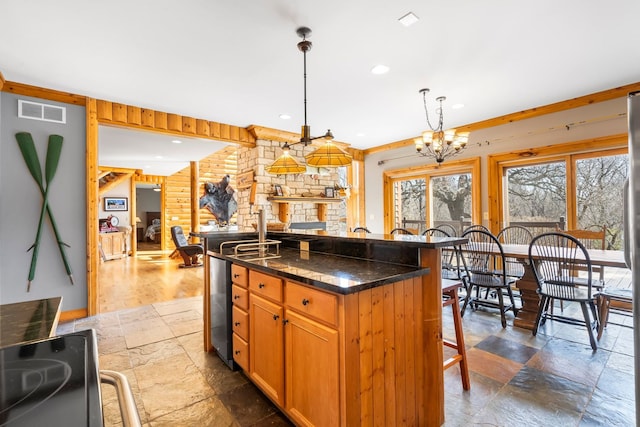 10A52 Cardinal Ct, Apple River, IL 61001 - kitchen with stone tile floors, a kitchen bar, a chandelier, a center island, and recessed lighting