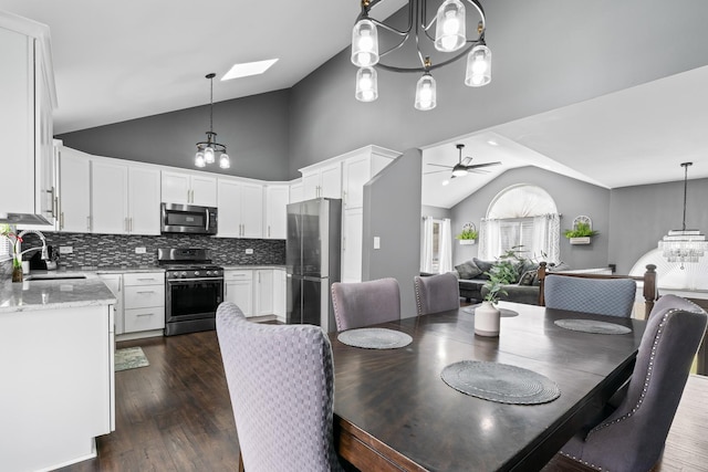 17408 Fisk Ave, East Hazel Crest, IL 60429 - dining room featuring vaulted ceiling, ceiling fan, dark wood-style floors, a skylight, and a chandelier