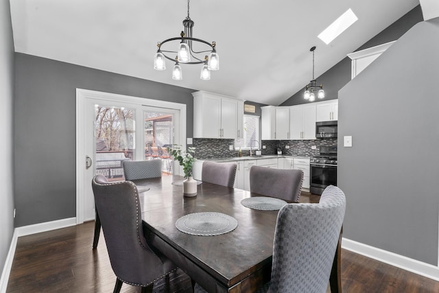 17408 Fisk Ave, East Hazel Crest, IL 60429 - dining room with a chandelier, vaulted ceiling, dark wood-type flooring, baseboards, and a skylight