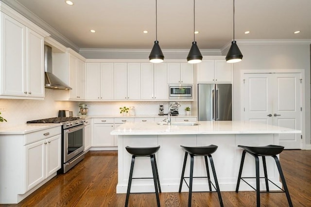 742 N Ada St Unit 3S, Chicago, IL 60642 - kitchen featuring appliances with stainless steel finishes, wall chimney range hood, a sink, ornamental molding, and a kitchen bar