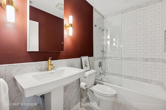 843 W Monroe St Unit 3B, Chicago, IL 60607 - bathroom featuring tile walls, toilet, washtub / shower combination, and a wainscoted wall