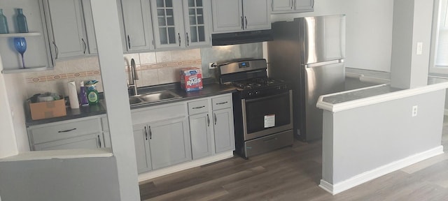 10324 S Eberhart Ave, Chicago, IL 60628 - kitchen featuring stainless steel appliances, under cabinet range hood, a sink, dark wood-style flooring, and tasteful backsplash