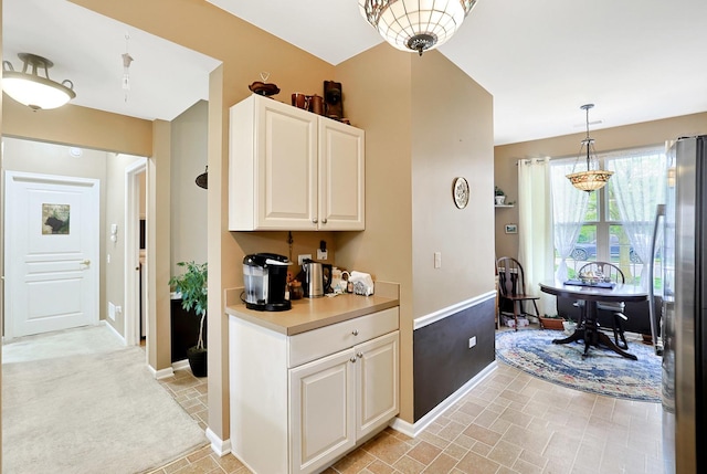 13538 Lehigh St, Huntley, IL 60142 - kitchen featuring freestanding refrigerator, baseboards, pendant lighting, light countertops, and white cabinetry
