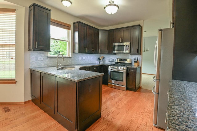 1804 Westbrook Ct, Plainfield, IL 60586 - kitchen with stainless steel appliances, a sink, light wood-style flooring, dark stone countertops, and decorative backsplash