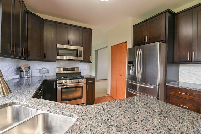 1804 Westbrook Ct, Plainfield, IL 60586 - kitchen featuring stainless steel appliances, stone counters, decorative backsplash, dark brown cabinets, and a sink